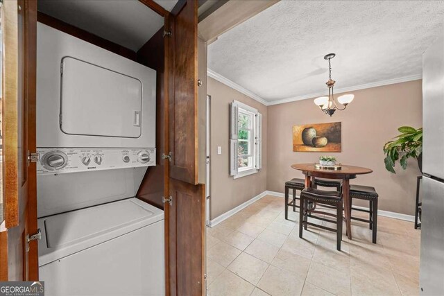 331 Lakemoore Dr NE Unit C, Atlanta, GA 30342 - laundry area featuring laundry area, stacked washing maching and dryer, baseboards, light tile patterned floors, and ornamental molding