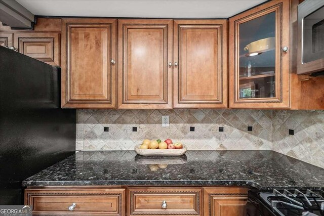 331 Lakemoore Dr NE Unit C, Atlanta, GA 30342 - kitchen featuring glass insert cabinets, brown cabinetry, black appliances, and backsplash