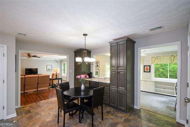 dining space featuring stone finish flooring, visible vents, and plenty of natural light