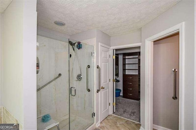 full bathroom with a textured ceiling and a stall shower