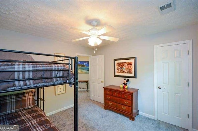bedroom featuring carpet floors, a textured ceiling, baseboards, and visible vents