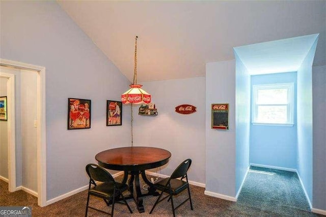 dining space with baseboards, dark carpet, and lofted ceiling