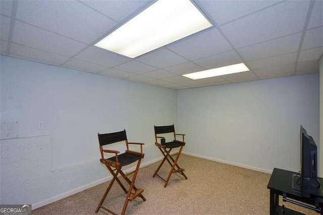 sitting room with carpet floors, a paneled ceiling, and baseboards