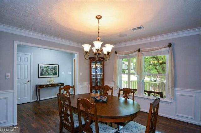 dining area with a wainscoted wall, a decorative wall, wood finished floors, and a chandelier