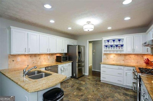 kitchen with white cabinets, open shelves, light stone countertops, a sink, and stainless steel appliances