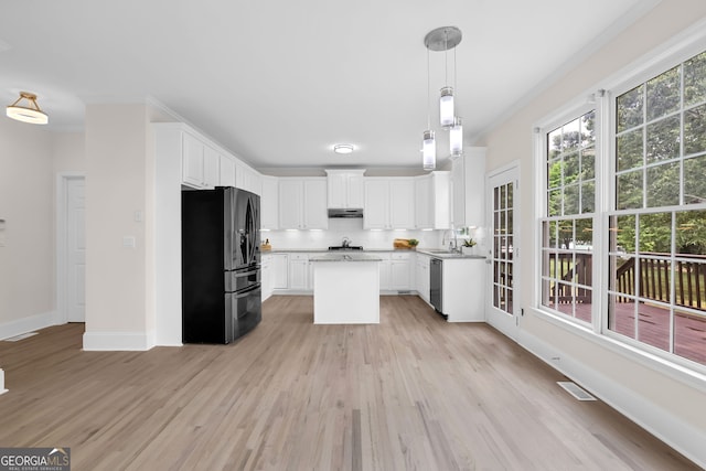 kitchen featuring black fridge, dishwasher, under cabinet range hood, and light wood-style floors