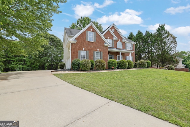 view of front of property with concrete driveway, brick siding, and a front lawn