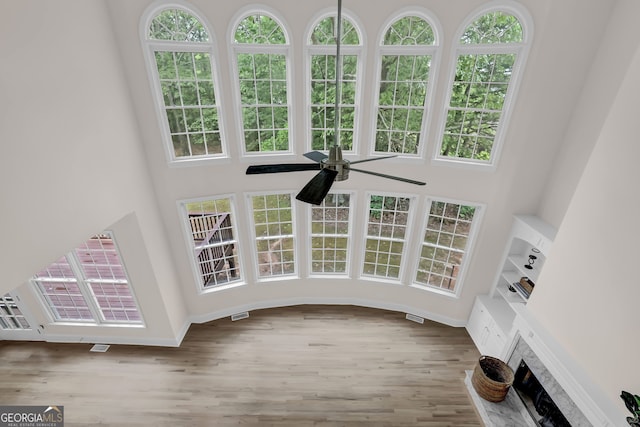 interior space featuring a fireplace, ceiling fan, and wood finished floors
