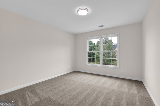 unfurnished room featuring carpet floors, baseboards, and visible vents