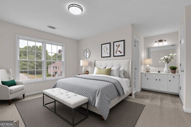 bedroom with baseboards, ensuite bath, visible vents, and light colored carpet