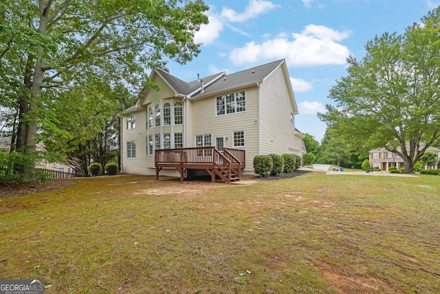 rear view of property featuring a yard and a deck
