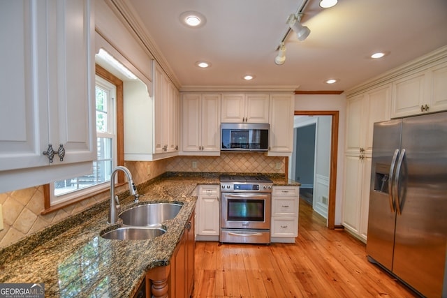 615 Woodwork Way, Roswell, GA 30076 - kitchen featuring dark stone counters, tasteful backsplash, a sink, light wood-style flooring, and appliances with stainless steel finishes