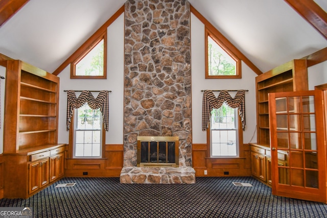 615 Woodwork Way, Roswell, GA 30076 - interior space with dark carpet, a stone fireplace, a wainscoted wall, and high vaulted ceiling