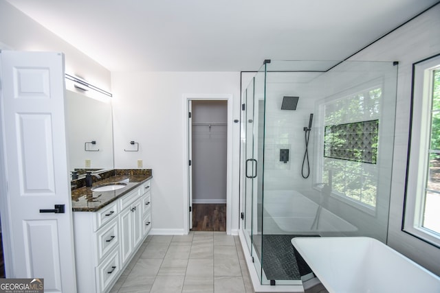 615 Woodwork Way, Roswell, GA 30076 - full bathroom featuring a walk in closet, a stall shower, vanity, baseboards, and a soaking tub