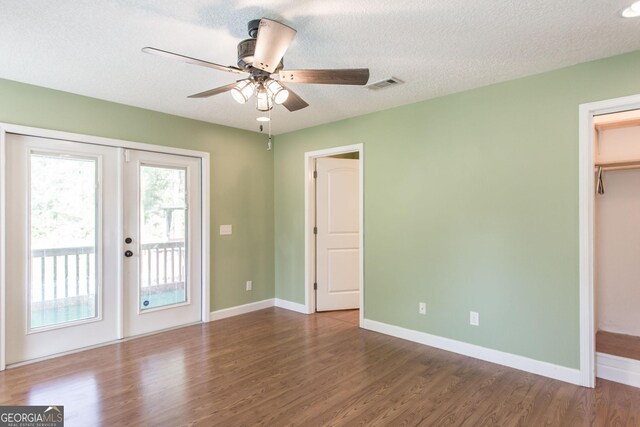 interior space with baseboards, access to exterior, dark wood finished floors, and visible vents