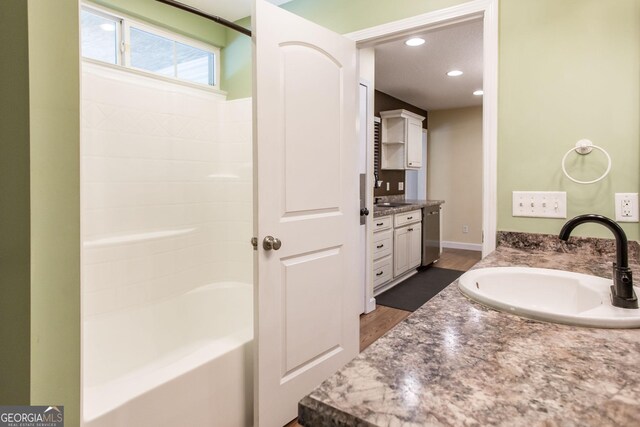 bathroom with vanity, recessed lighting, baseboards, and wood finished floors