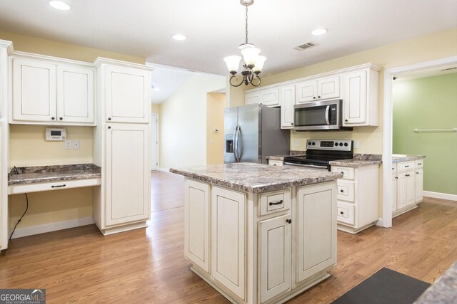 kitchen featuring a notable chandelier, hanging light fixtures, stainless steel appliances, a kitchen island, and visible vents