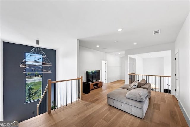 interior space with baseboards, recessed lighting, wood finished floors, and visible vents