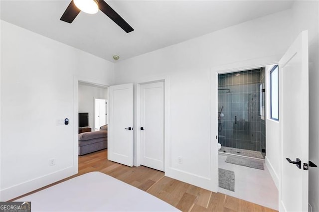 bedroom featuring baseboards, connected bathroom, ceiling fan, and wood finished floors
