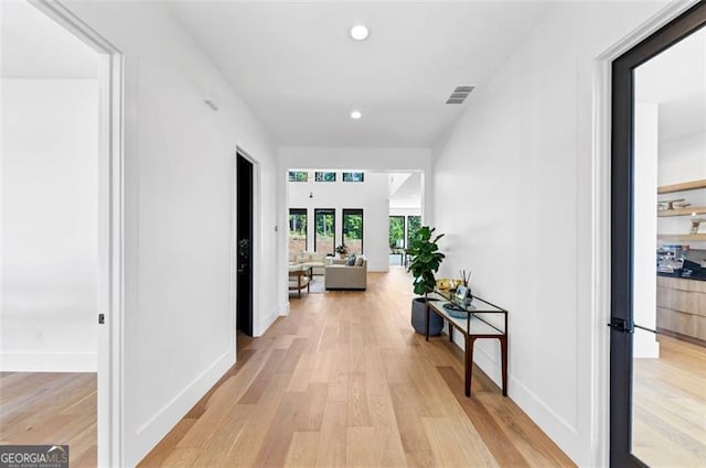 hallway with visible vents, recessed lighting, light wood-style flooring, and baseboards