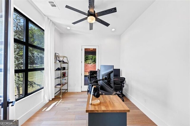 office area featuring visible vents, a ceiling fan, light wood-style flooring, and baseboards