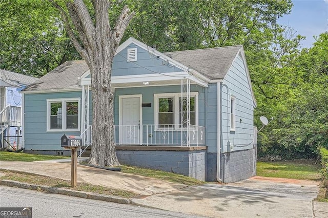 bungalow-style house with a porch and a shingled roof