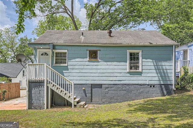 back of house with fence and a yard