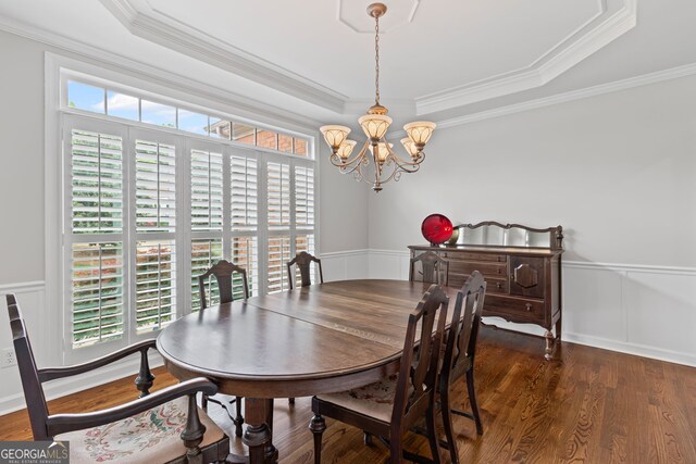 dining room with an inviting chandelier, wainscoting, crown molding, and a tray ceiling