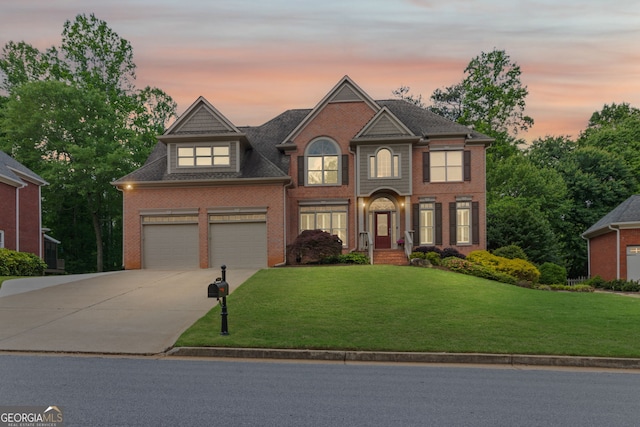 traditional home featuring an attached garage, concrete driveway, a front lawn, and brick siding