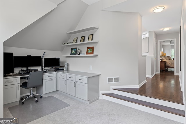 office area featuring built in study area, baseboards, lofted ceiling, and visible vents