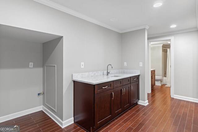 bar featuring ornamental molding, baseboards, dark wood-style floors, recessed lighting, and a sink