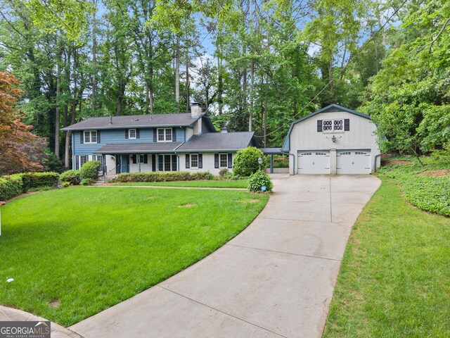 view of front of property featuring an outbuilding, a front lawn, driveway, and a chimney