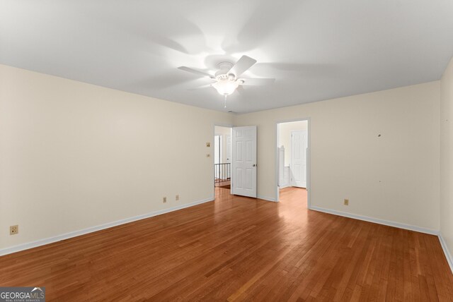 unfurnished room with baseboards, a ceiling fan, and wood finished floors