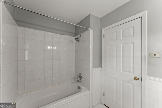 full bath featuring  shower combination and wainscoting