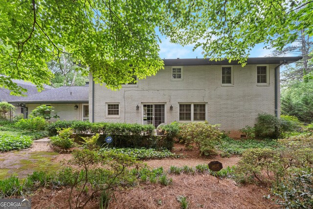back of property featuring brick siding and crawl space