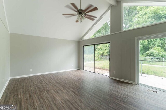 6255 Saddlewood Dr, Lithonia, GA 30058 - empty room with high vaulted ceiling, wood finished floors, ceiling fan, beam ceiling, and healthy amount of natural light