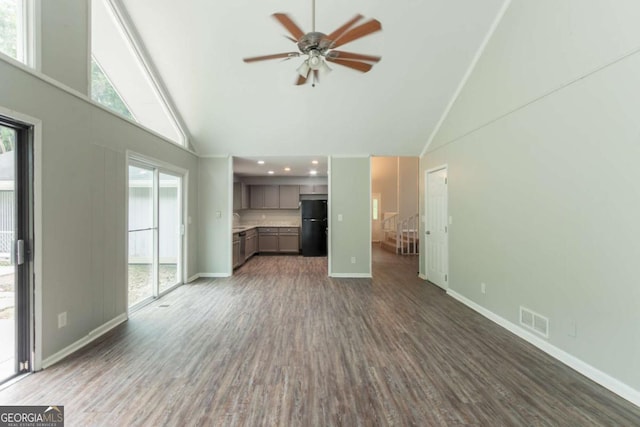 6255 Saddlewood Dr, Lithonia, GA 30058 - unfurnished living room with high vaulted ceiling, a ceiling fan, and dark wood-type flooring