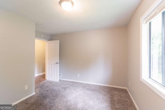 6255 Saddlewood Dr, Lithonia, GA 30058 - empty room with healthy amount of natural light, a textured ceiling, and carpet