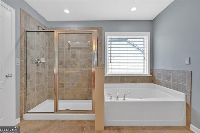 full bathroom featuring a shower stall, a bath, and tile patterned flooring
