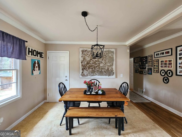 dining space with baseboards, a notable chandelier, and ornamental molding