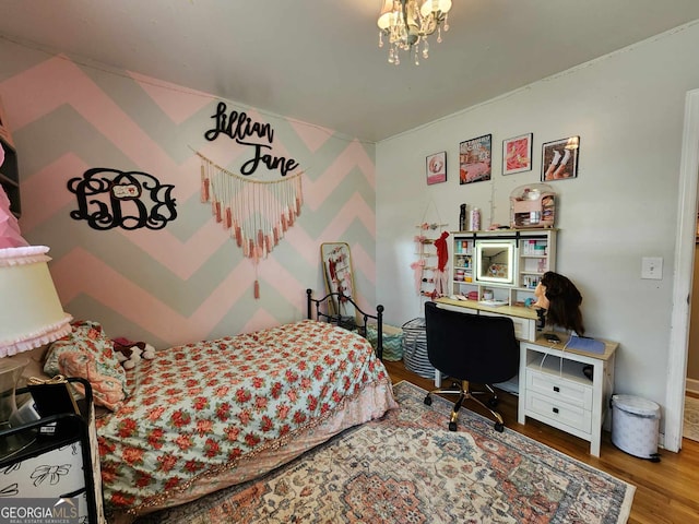 bedroom with wood finished floors and a chandelier