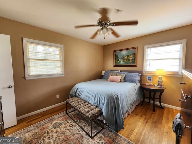 bedroom with baseboards, ceiling fan, and hardwood / wood-style flooring