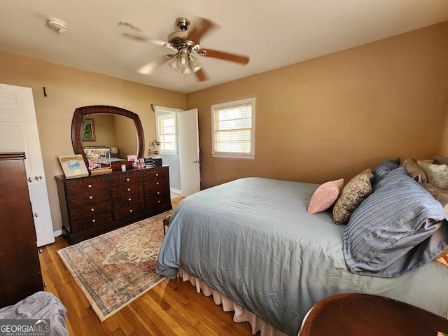 bedroom with a ceiling fan, baseboards, and wood finished floors