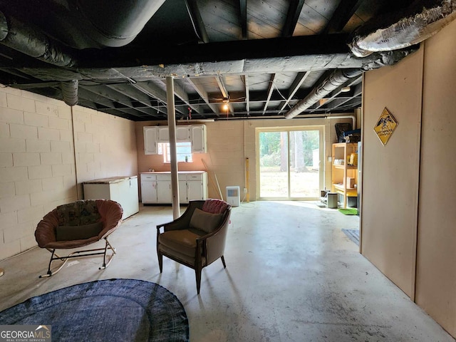below grade area with concrete block wall and refrigerator