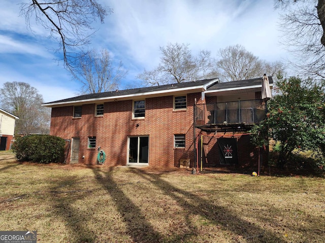 back of property featuring a chimney, a yard, and brick siding