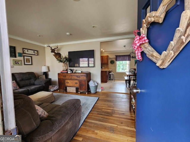living area with crown molding, baseboards, and wood finished floors