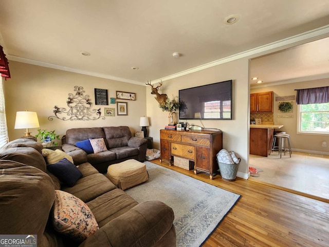 living room featuring crown molding, baseboards, recessed lighting, and light wood-type flooring