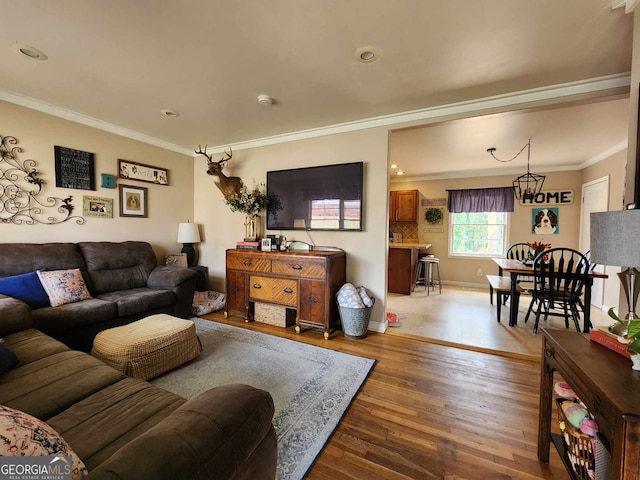 living area with crown molding, baseboards, and wood finished floors