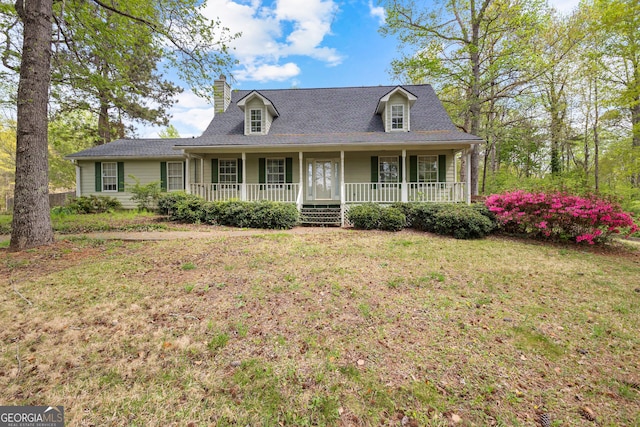 view of front of house featuring a porch, a chimney, and a front yard