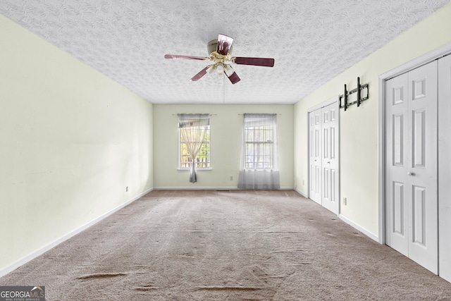 interior space with carpet floors, ceiling fan, and baseboards